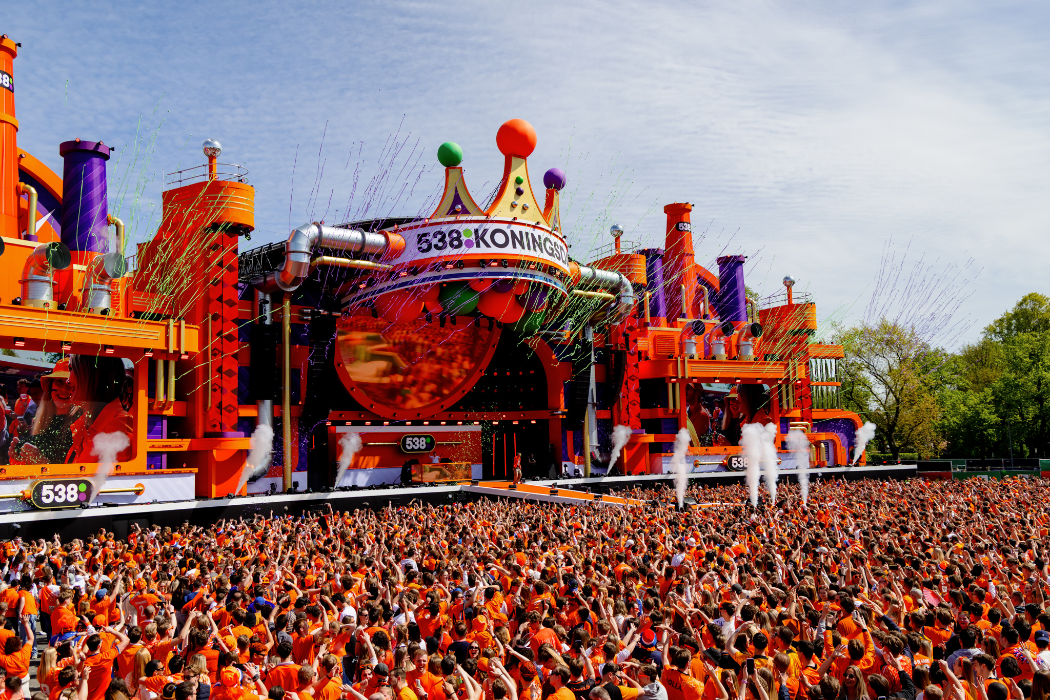 Orange crowd in front of the 538Koningsdag stage with confetti and smoke