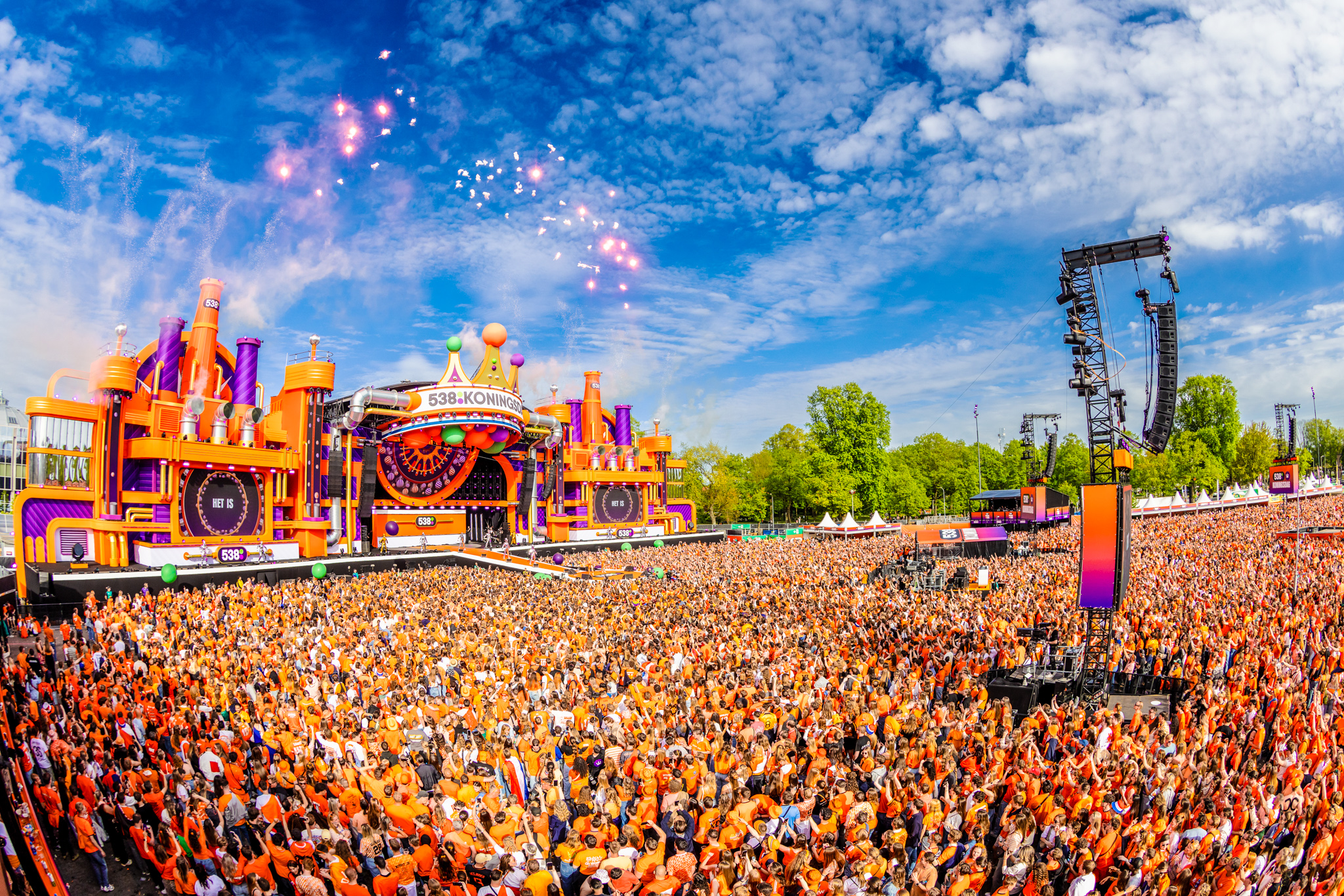 Fireworks over the 538Koningsdag 2026 stage and orange crowd under blue sky