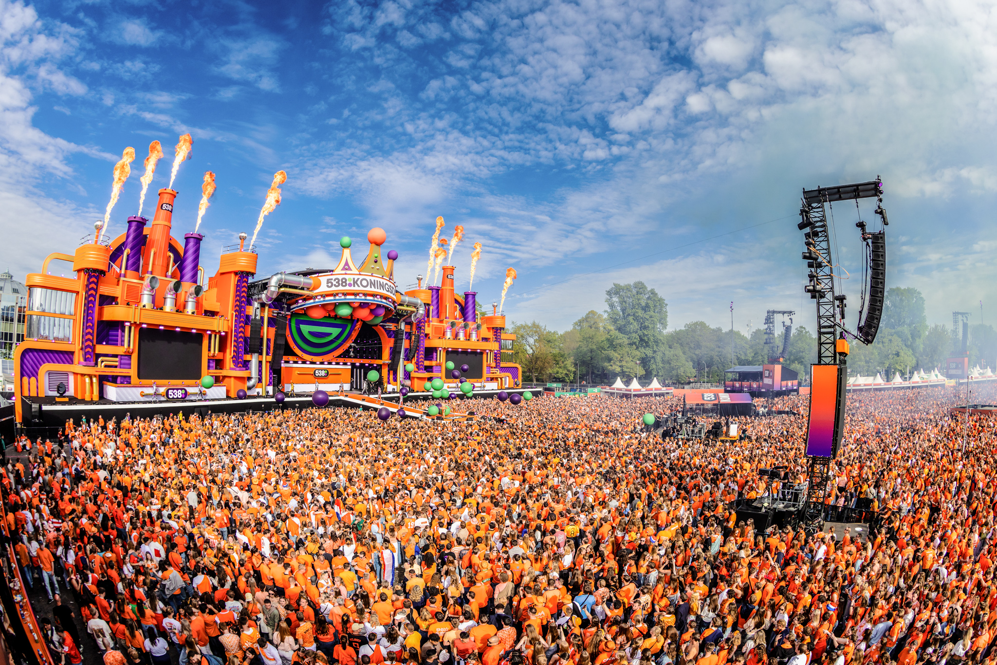 Flame bursts on the 538Koningsdag 2026 stage above a packed orange crowd