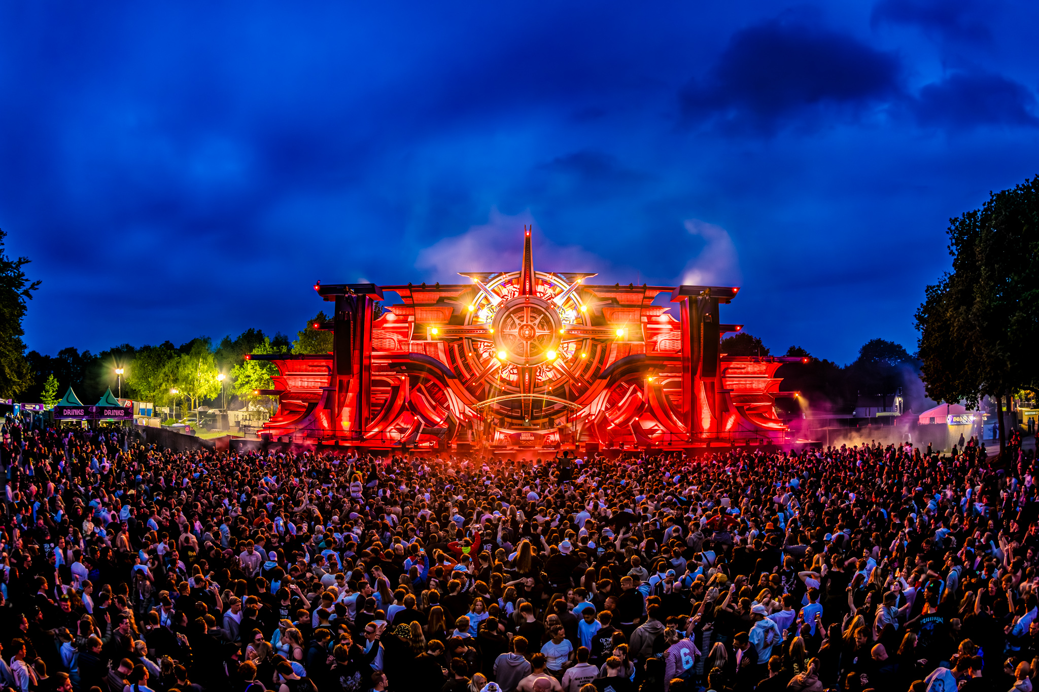 Red-lit stage and crowd under a deep blue evening sky at Dance4Liberation 2026
