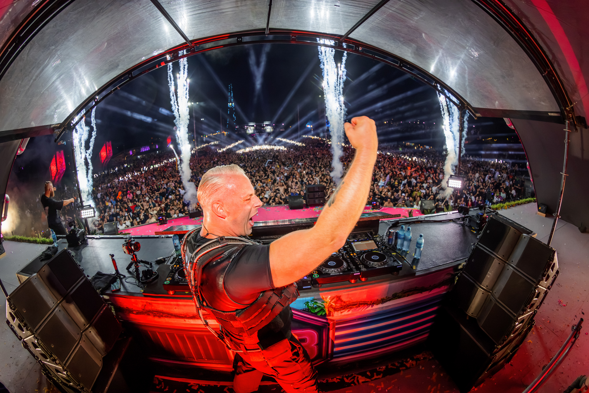 DJ cheering behind the decks with a view of the crowd at Decibel Outdoor Festival 2026