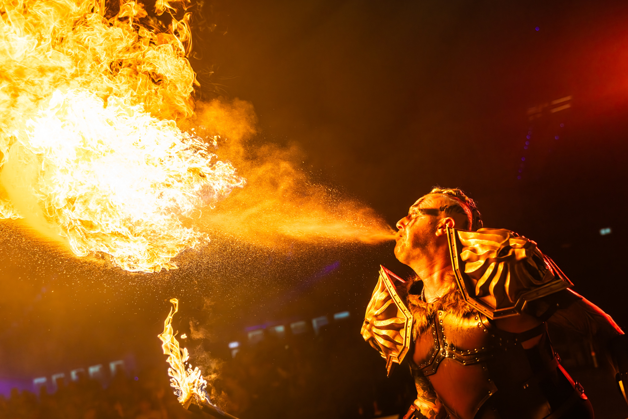 Fire breather in golden armour blowing a fireball at Avondje Outsiders 2026