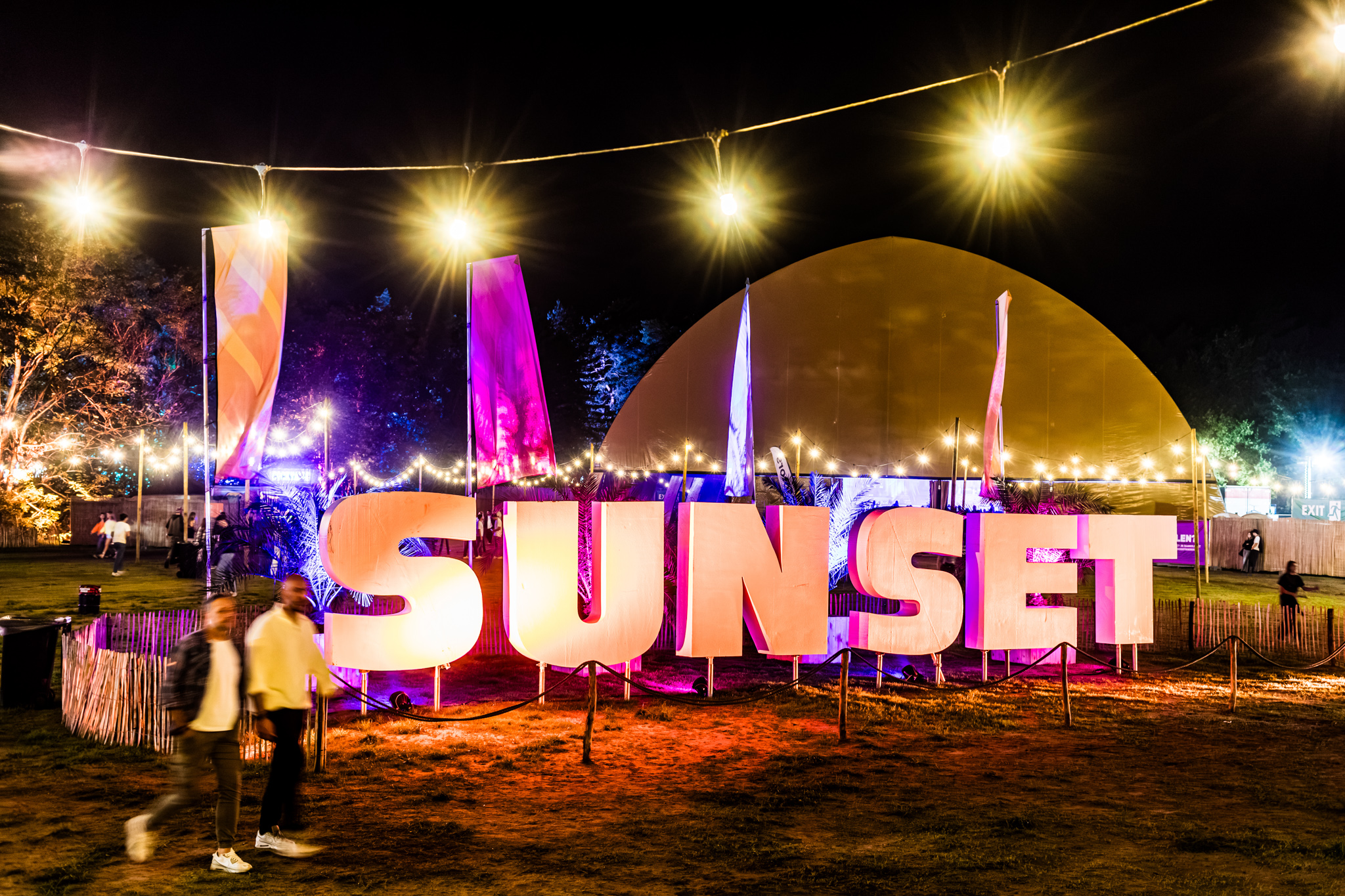 Illuminated SUNSET letters and festoon lights at night, Sunset Festival 2026